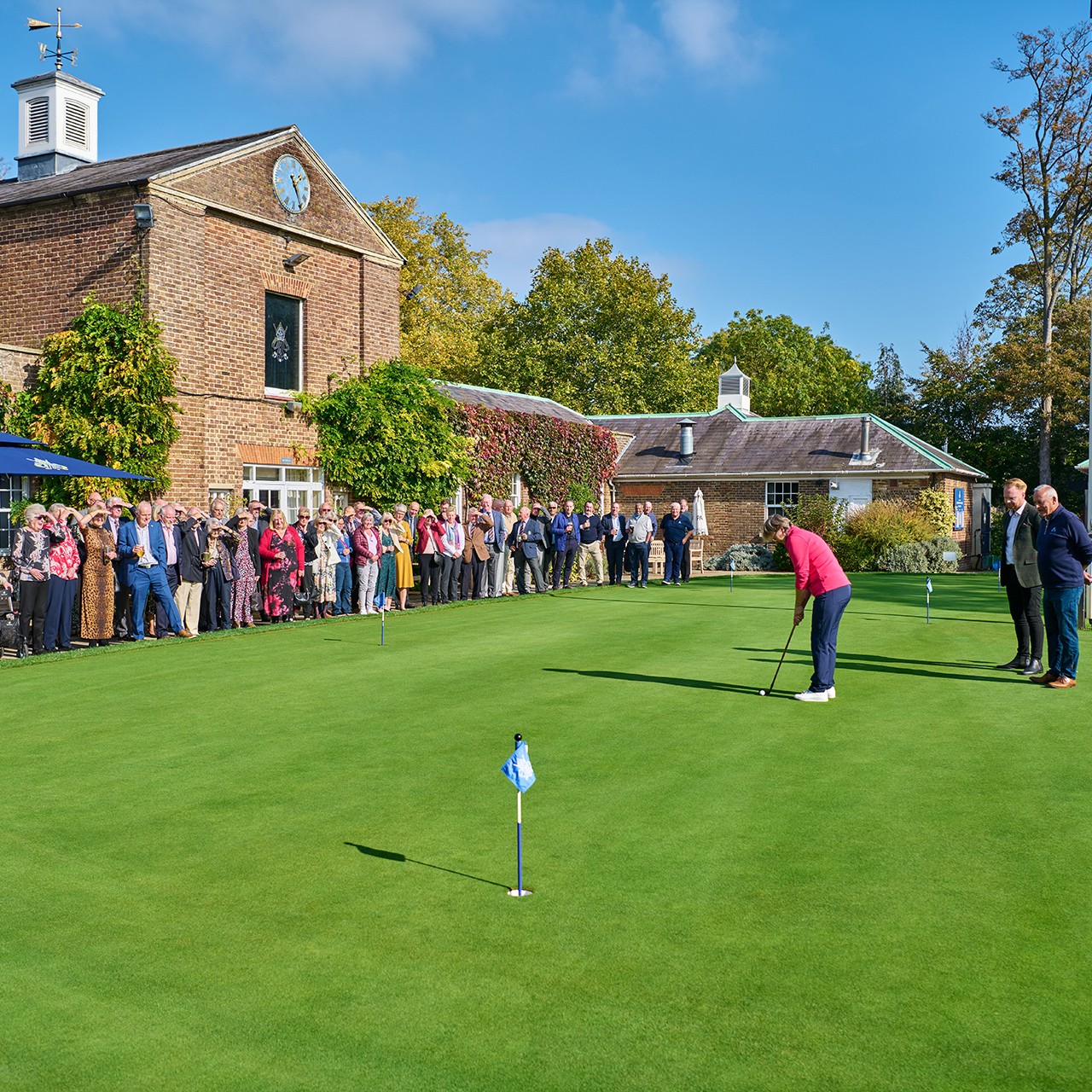 Event guests watching a putting demonstration on the putting green at Addington Palace Golf Club
