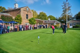 Event guests watching a putting demonstration on the putting green at Addington Palace Golf Club